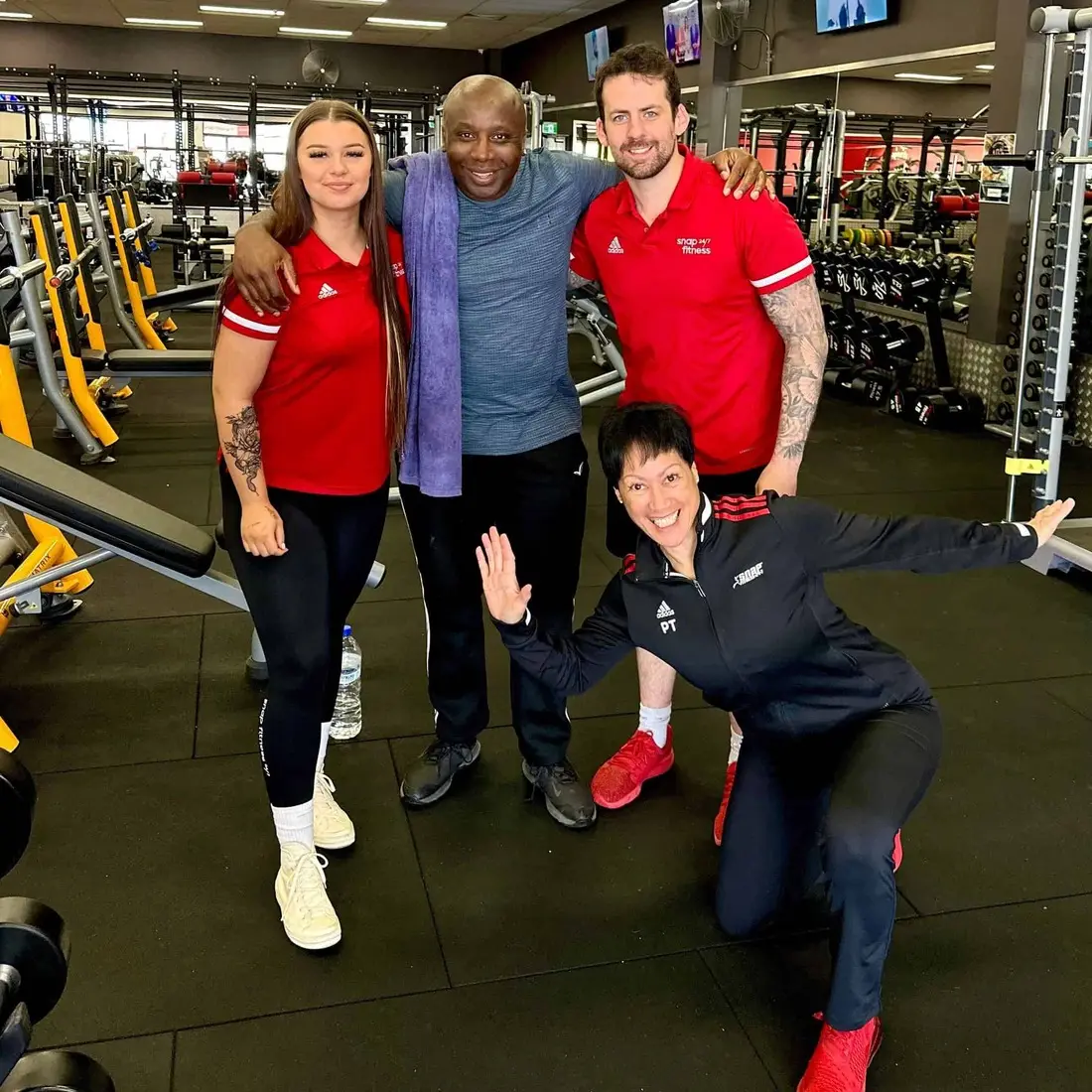 Carlton Treasure with three clients in Glutrition red at the gym